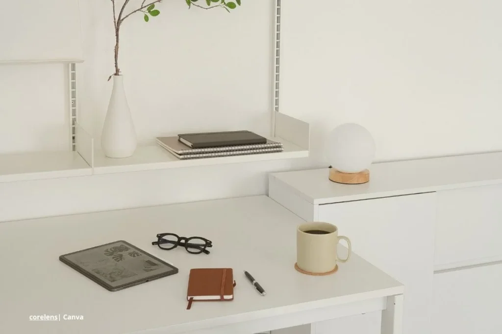Escritorio minimalista con cuaderno, gafas y taza de café, símbolo de hogares saludables.