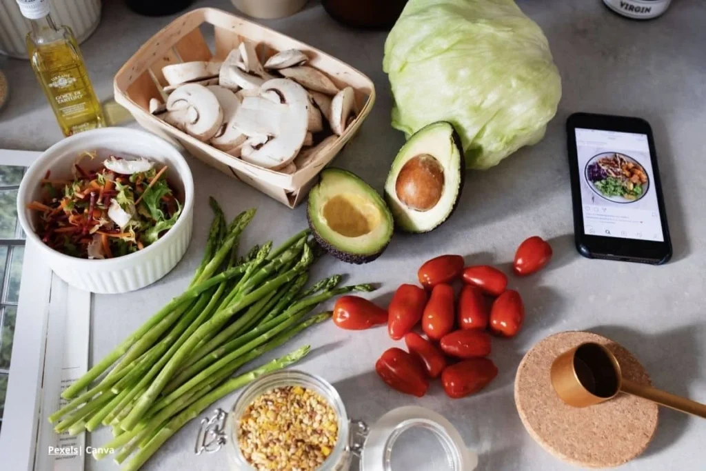 Alimentación antiinflamatoria con aguacate, espárragos, champiñones, lechuga y tomates frescos sobre mesa de cocina.