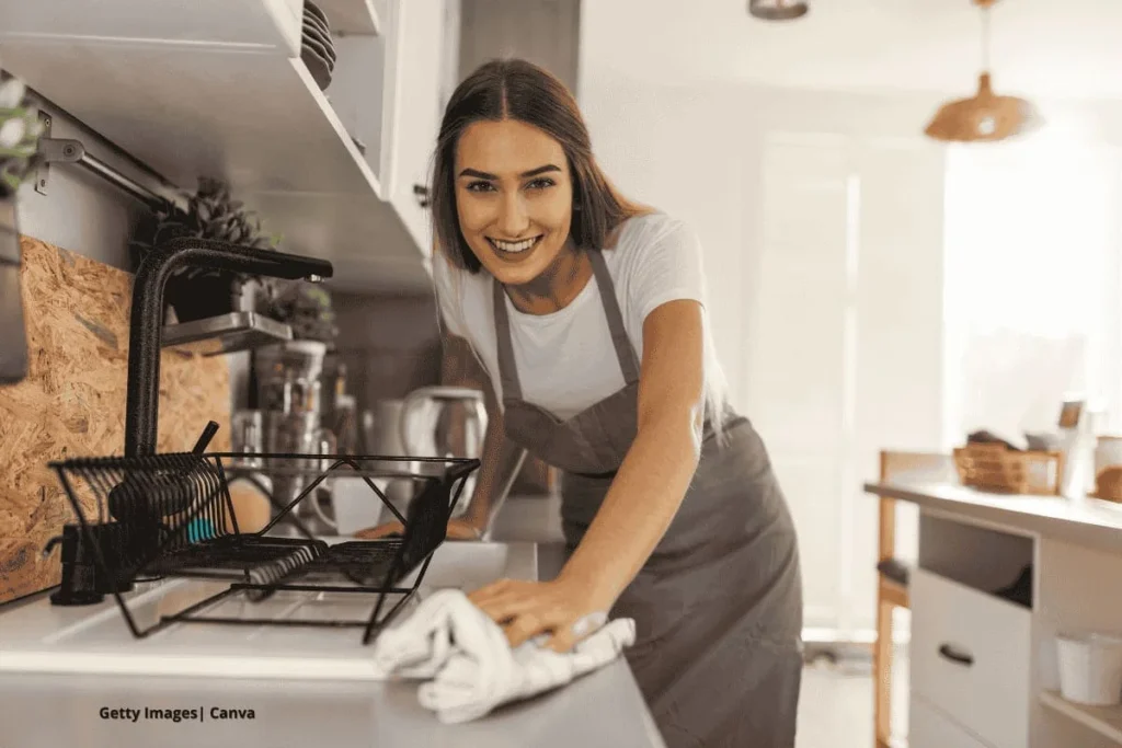Mujer limpiando encimera cocina sonriente, productos saludables.