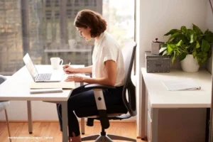 Plantas oficina en casa: mujer trabajando con laptop junto a planta de interior